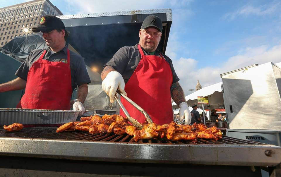 A man grilling chicken wings during National Buffalo Wing Festival, an barbecue event not to be missed in September.