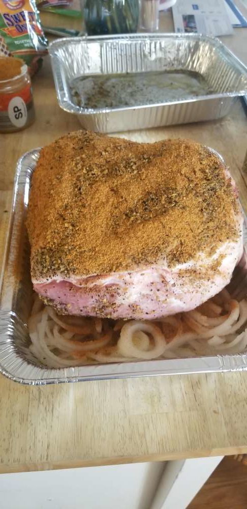The seasoned pork butt is then laid directly on this layer of onions.