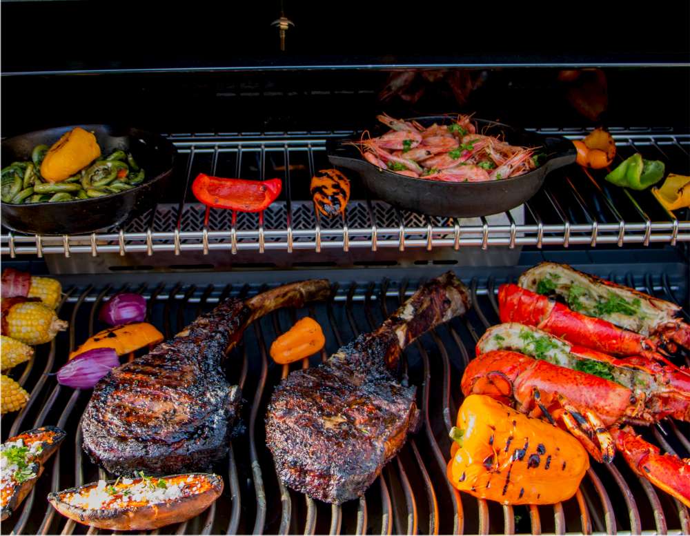 Perfectly cooked Tomahawk steak on the BBQ with vegetables and lobsters. How to cook the perfect Tomahawk steak?