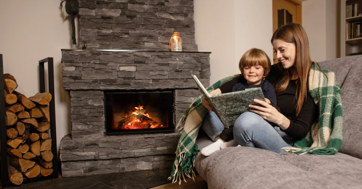 A mother and son cuddle by the fireplace reading a book while mindful of fireplace safety